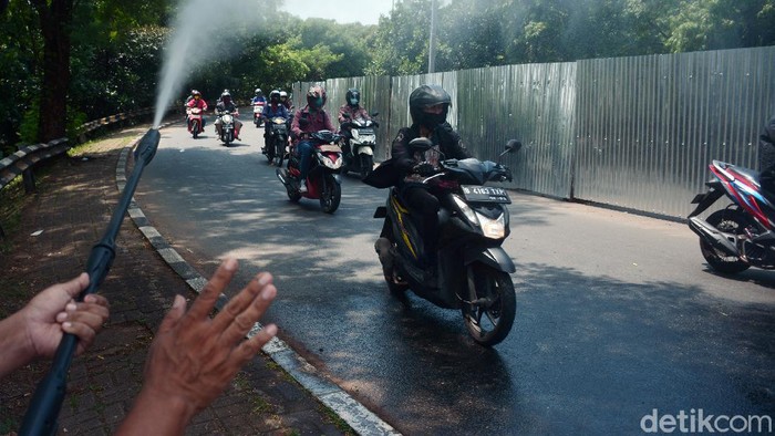 Kendaraan truk berplat nomor wilayah Bogor disemprotkan dengan cairan probiotik untuk mencegah penyebaran virus saat melintas di jalan perbatasan antar kota Depok dan Jakarta