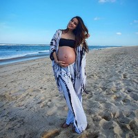 Mengenakan kemben dan setelan cardigan, Sheila Marcia tampak menebar senyum di tepi pantai. Maternity shoot ini digarap sendiri oleh sang suami, Dimas Akira. Foto: Instagram/@itssheilamj