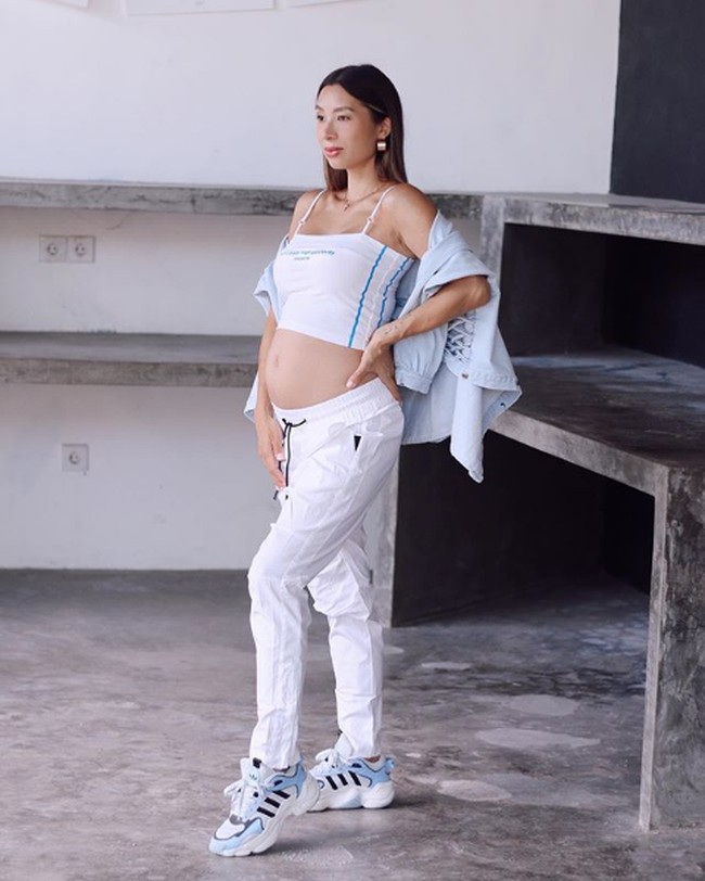 Jennfier Bachdim yang sedang menanti anak ketiga memperlihatkan perutnya yang hamil besar dengan gaya sporty nan seksi. Mengenakan crop top putih dan celana training serta sneakers, lifestyle influencer ini menunjukkan tubuhnya yang masih fit meskipun sedang hamil. Foto: Instagram/@jenniferbachdim