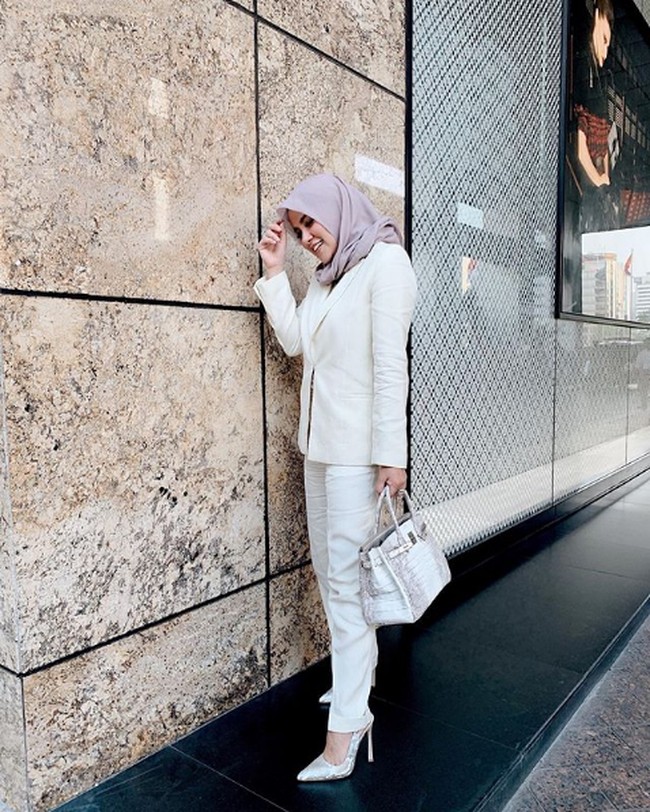 Bergaya serba putih, Olla Ramlan menenteng tas Hermes Birkin White-Matte Himalayan favoritnya. Dalam wawancara untuk channel YouTube Robby Purba, Olla pernah mengungkapkan alasannya suka membeli tas Hermes. Menurunya tas tersebut adalah reward dari hasil kerja kerasnya. Foto: Instagram