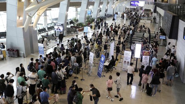 Passengers wearing face masks to help protect against the spread of the coronavirus line up to board planes ahead of the upcoming Chuseok holiday, the Korean version of Thanksgiving Day, at the domestic flight terminal of Gimpo airport in Seoul, South Korea, Wednesday, Sept. 30, 2020. (AP Photo/Ahn Young-joon)