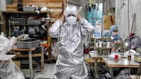 Sejumlah pekerja mengerjakan pembuatan APD (alat pelindung diri) hazmat dan masker.