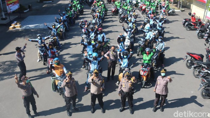 polisi di Bojonegoro membagikan paket sembako dan masker ke Ojol
