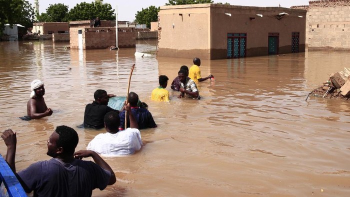 A Sudanese man stands in flood water, after torrential rain lead to landslides and flash floods, in the town of Umm Dawan Ban, southeast of the capital Khartoum on August 2, 2020. (Photo by ASHRAF SHAZLY / AFP)