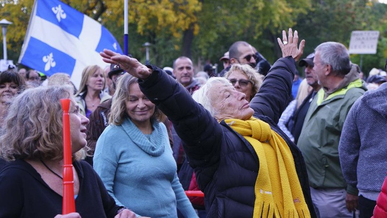 Ikut Demo Antimasker, Orang-orang Pakai Masker Aneh Police ask participants to respect physical distancing during the coronavirus pandemic at an anti-mask rally in Montreal, on Wednesday, Sept. 30, 2020. (Paul Chiasson/The Canadian Press via AP)