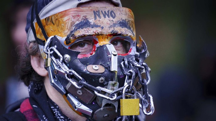 Ikut Demo Antimasker, Orang-orang Pakai Masker Aneh Police ask participants to respect physical distancing during the coronavirus pandemic at an anti-mask rally in Montreal, on Wednesday, Sept. 30, 2020. (Paul Chiasson/The Canadian Press via AP)