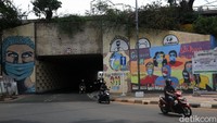 Pengendara Sepeda motor melintas di dekat mural bertemakan kampanye protokol kesehatan COVID-19 di sekitar Terowongan Stasiun Cawang, Jakarta, Kamis (1/10/2020).  