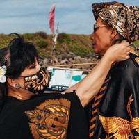 Tampak perempuan yang suka bergaya urakan itu beraksi dalam balutan atasan hitam yang dipadu dengan rok batik megar nan dramatis di atas perahu nelayan. Ia juga memaksimalkan gayanya dengan kacamata hitam. (Foto: Dok. Anne Avantie)