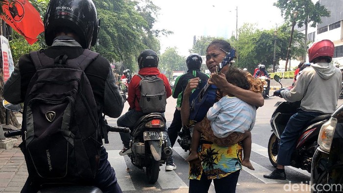 Mengamen kerap dilakukan sejumlah orang untuk bertahan hidup di tengah kerasnya Ibu Kota. Tak jarang sejumlah ibu membawa serta anaknya saat mengamen.