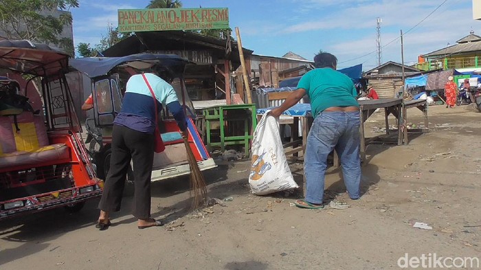 Warga langgar protokol kesehatan di Polman disanksi bersih pasar (Abdy-detikcom).