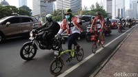 Dua orang pesepeda yang mengenakan batik melintas di antara kendaraan di kawasan Sudirman. Mereka kompak mengenakan busana tersebut untuk memperingati Hari Batik Nasional.