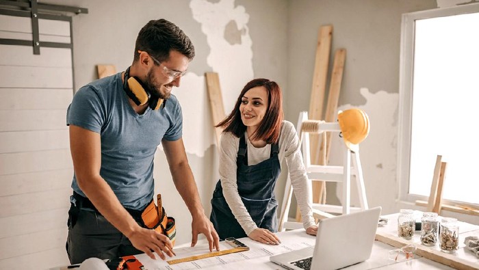 Woman analyzing blueprint for her new home interior