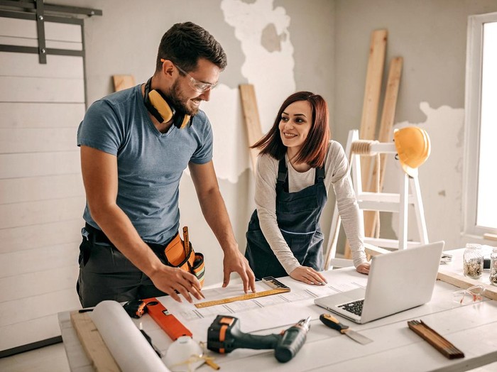 Woman analyzing blueprint for her new home interior