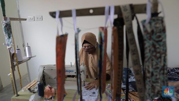 Perajin memproduksi masker batik di Sentra Kerajinan Batik Tradisiku, Kota Bogor, Jawa Barat, Jumat (2/10/2020). Pemerintah tanggal 2 Oktober sebagai Hari Batik Nasional. Penetapan tersebut berlandaskan keputusan Perserikatan Bangsa-Bangsa (PBB) yang menetapkan batik menjadi warisan budaya dunia dari Indonesia. Galeri Batik ini merupakan salah satu pusat di mana pengunjung dapat melihat dan memesan batik yang desainnya amat kental dengan nuansa Kota Bogor. Biasanya wisatawan yang hadir ke Bogor bisa melihat dan mengunjungi Galeri Batik ini. Karena adanya aturan PSBB  membuat turis asing tidak bisa datang. Ragam desainnya pun rupa-rupa mulai dari motif hujan gerimis, kujang, Kebun Raya, Istana Bogor, dan Batu Tulis. Untuk saat ini perajin sedang garap masker dengan motif batik standar SNI. Seperti diketahui Badan Standardisasi Nasional (BSN) mengeluarkan spesifikasi masker kain ber-SNI yang terbagi menjadi tiga tipe berdasarkan penggunaannya, antara lain tipe A untuk penggunaan umum, tipe B untuk penggunaan filtrasi bakteri, dan tipe C untuk penggunaan filtrasi partikel. (CNBC Indonesia/ Muhammad Sabki