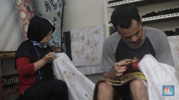 Perajin memproduksi masker batik di Sentra Kerajinan Batik Tradisiku, Kota Bogor, Jawa Barat, Jumat (2/10/2020). Pemerintah tanggal 2 Oktober sebagai Hari Batik Nasional. Penetapan tersebut berlandaskan keputusan Perserikatan Bangsa-Bangsa (PBB) yang menetapkan batik menjadi warisan budaya dunia dari Indonesia. Galeri Batik ini merupakan salah satu pusat di mana pengunjung dapat melihat dan memesan batik yang desainnya amat kental dengan nuansa Kota Bogor. Biasanya wisatawan yang hadir ke Bogor bisa melihat dan mengunjungi Galeri Batik ini. Karena adanya aturan PSBB  membuat turis asing tidak bisa datang. Ragam desainnya pun rupa-rupa mulai dari motif hujan gerimis, kujang, Kebun Raya, Istana Bogor, dan Batu Tulis. Untuk saat ini perajin sedang garap masker dengan motif batik standar SNI. Seperti diketahui Badan Standardisasi Nasional (BSN) mengeluarkan spesifikasi masker kain ber-SNI yang terbagi menjadi tiga tipe berdasarkan penggunaannya, antara lain tipe A untuk penggunaan umum, tipe B untuk penggunaan filtrasi bakteri, dan tipe C untuk penggunaan filtrasi partikel. (CNBC Indonesia/ Muhammad Sabki