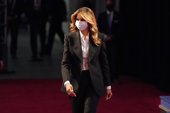 Tiba di lokasi acara, Melania Trump tampak mengenakan masker berwarna putih. (Foto: AP/Julio Cortez)