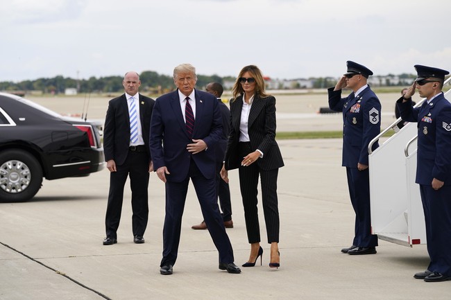 Untuk kesempatan tersebut, Melania Trump bergaya kembar dengan sang suami. Mantan model asal Slovakia itu menukar gaun cantiknya dengan setelan hitam bermotif garis (pin-striped). (Foto: AP/Julio Cortez)