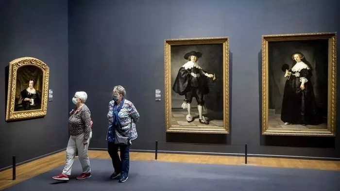 Warga di Amsterdam pakai masker saat dalam ruangan museum (AFP Photo)
