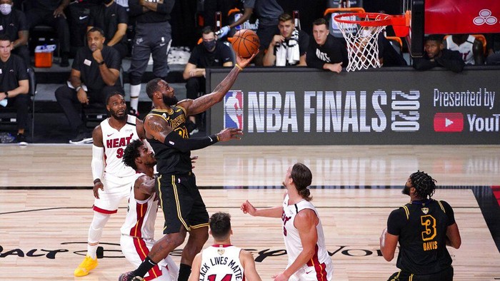 Los Angeles Lakers forward LeBron James (23) goes up for a shot between Miami Heats Jimmy Butler, center left, Tyler Herro (14), and Kelly Olynyk (9) during the second half of Game 2 of basketballs NBA Finals, Friday, Oct. 2, 2020, in Lake Buena Vista, Fla. (AP Photo/Mark J. Terrill)