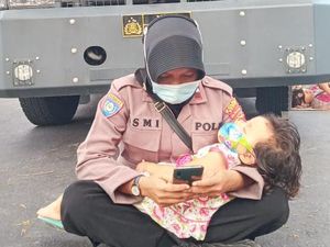 Viral Foto Polwan Gendong Anak Jaga Aksi Demo Pilkada di Dompu