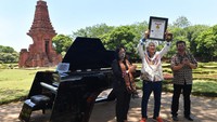 Direktur Perfilman, Musik dan Media Baru Kemendikbud Ahmad Mahendra (kanan) bersama Senior Manager MURI Sri Widayati (kiri) menyaksikan Presiden Direktur PT Saniharto Enggalhardjo Harsono Enggalhardjo (tengah) mengangkat piagam MURI untuk grand piano pertama buatan Indonesia saat digelar rangkaian konser Raspodia Nusantara dan Kejayaan Nusantara di Candi Gapura Bajang Ratu, Trowulan, Mojokerto, Jawa Timur, Sabtu (3/10/2020).