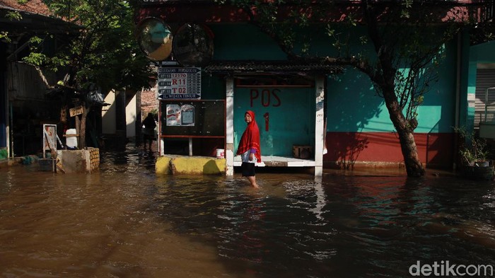 Warga beraktivitas di tengah banjir di Kelurahan Petogogan, Jakarta Selatan, Senin (5/10/20200). Banjir akibat hujan sejak Minggu (4/10/2020) malam dan luapan sungai Krukut yang membelah Petogogan. (ARI SAPUTRA/detikcom)