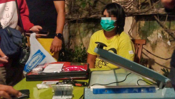 Ibu rumah tangga berinisial TI (tengah) bersama barang bukti kasus narkoba saat penggeledahan di rumahnya, Sumbawa, NTB (ANTARA/Ditresnarkoba Polda NTB)