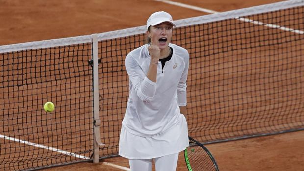 Poland's Iga Swiatek celebrates winning as Romania's Simona Halep's return missed, ball at left, in the fourth round match of the French Open tennis tournament at the Roland Garros stadium in Paris, France, Sunday, Oct. 4, 2020. (AP Photo/Alessandra Tarantino)