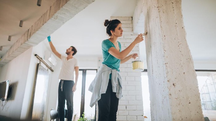 Young couple painting their living room