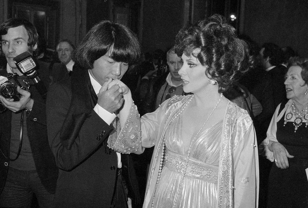 Kenzo Takada FILE - In this Dec. 16, 1977 file photo, designer Kenzo Takada kisses the hand of Italian actress Gina Lollobrigida after she awarded him as one of the ten most elegant men in the world in Rome, Italy. Fashion designer Kenzo Takada dies from COVID-19 complications at age 81 near Paris, spokeswoman and reports said Sunday Oct. 4, 2020. (AP Photo, file)