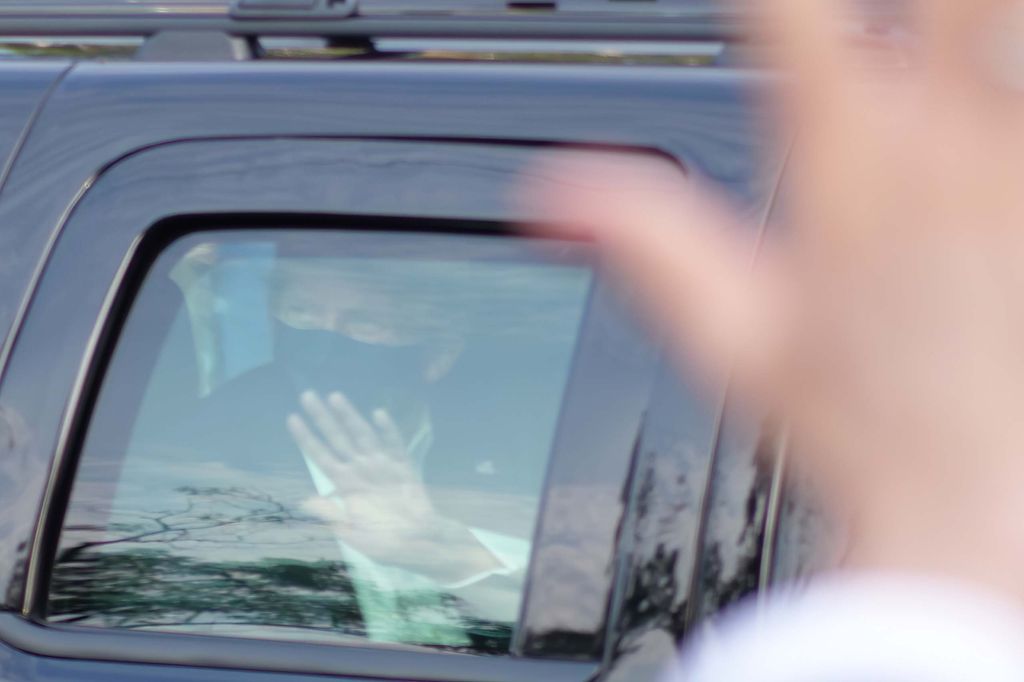 President Donald Trump drives past supporters gathered outside Walter Reed National Military Medical Center in Bethesda, Md., Sunday, Oct. 4, 2020. Trump was admitted to the hospital after contracting COVID-19. (AP Photo/Anthony Peltier)