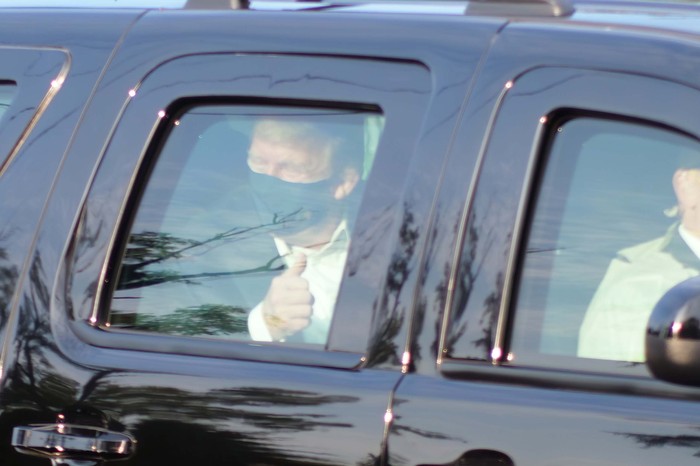 President Donald Trump drives past supporters gathered outside Walter Reed National Military Medical Center in Bethesda, Md., Sunday, Oct. 4, 2020. Trump was admitted to the hospital after contracting COVID-19. (AP Photo/Anthony Peltier)