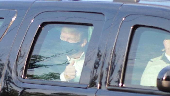 President Donald Trump drives past supporters gathered outside Walter Reed National Military Medical Center in Bethesda, Md., Sunday, Oct. 4, 2020. Trump was admitted to the hospital after contracting COVID-19. (AP Photo/Anthony Peltier)