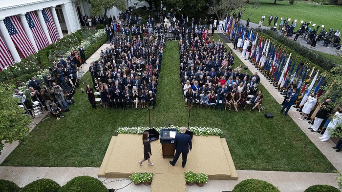 Judge Amy Coney Barrett walks to the microphone after President Donald Trump, right, announced Barrett as his nominee to the Supreme Court, in the Rose Garden at the White House, Saturday, Sept. 26, 2020, in Washington. (AP Photo/Alex Brandon)