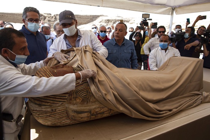 Penampakan Isi Satu dari 59 Sarkofagus yang Ditemukan Mesir Khalid el-Anany, Egyptβs tourism and antiquities minister, right, and Mostafa Waziri, secretary-general of the countryβs Supreme Council of Antiquities, left, stand over a sarcophagus at the Saqqara archaeological site, 30 kilometers (19 miles) south of Cairo, Egypt on Saturday, Oct. 3, 2020. El-Anany says at least 59 sealed sarcophagi with mummies inside were found in three wells at the vast necropolis, believed to have been buried there more than 2,600 years ago. (AP Photo/Mahmoud Khaled)