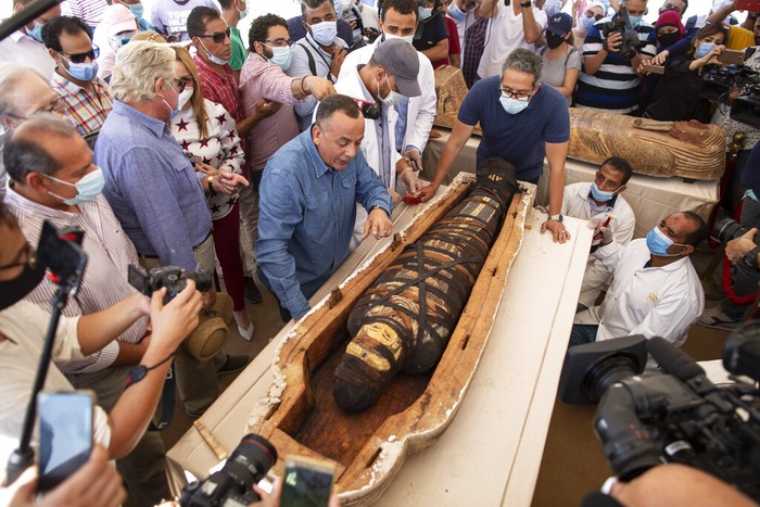 Penampakan Isi Satu dari 59 Sarkofagus yang Ditemukan Mesir Khalid el-Anany, Egyptβs tourism and antiquities minister, right, and Mostafa Waziri, secretary-general of the countryβs Supreme Council of Antiquities, left, stand over a sarcophagus at the Saqqara archaeological site, 30 kilometers (19 miles) south of Cairo, Egypt on Saturday, Oct. 3, 2020. El-Anany says at least 59 sealed sarcophagi with mummies inside were found in three wells at the vast necropolis, believed to have been buried there more than 2,600 years ago. (AP Photo/Mahmoud Khaled)