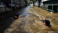 Genangan tersebut dimanfaatkan sejumlah anak untuk bermain air.