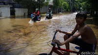 Meski jalan di kawasan tersebut tergenang, tak sedikit pengendara motor yang tampak hilir mudik melintasi jalan itu.
