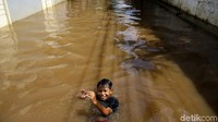 Seorang anak tampak asyik berenang di genangan yang terlihat di kawasan Kemang Selatan, Jakarta, Senin (5/10/2020).