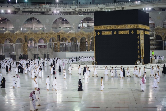 CLARIFIES THAT THE UMRAH PILGRIMAGE CAN BE UNDERTAKEN AT ANY TIME OF THE YEAR -- In this photo released by Saudi Ministry of Hajj and Umrah, Muslims practice social distancing while praying around the Kaaba, the cubic building at the Grand Mosque during the first day umrah pilgrimages were allowed to restart, in the Muslim holy city of Mecca, Saudi Arabia, Sunday, Oct. 4, 2020. The umrah pilgrimage, or smaller pilgrimage, can be undertaken at any time of the year. A very small, limited number of people donning the white terrycloth garment symbolic of the Muslim pilgrimage circled Islams holiest site in Mecca on Sunday after Saudi Arabia lifted coronavirus restrictions that had been in place for months. (Saudi Ministry of Hajj and Umrah via AP)