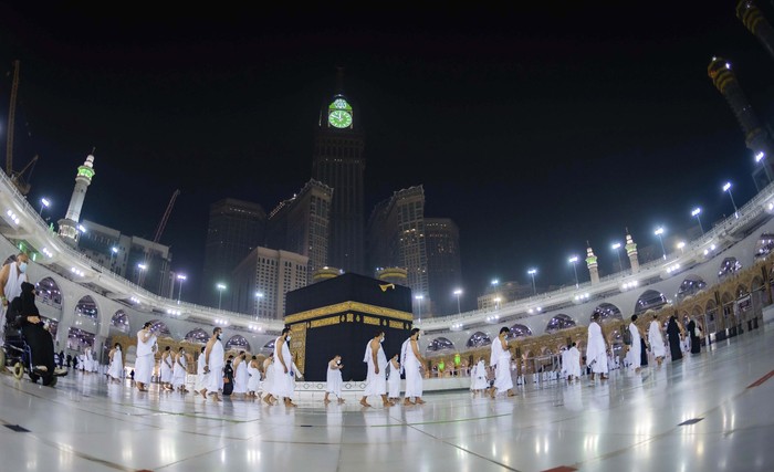 CLARIFIES THAT THE UMRAH PILGRIMAGE CAN BE UNDERTAKEN AT ANY TIME OF THE YEAR -- In this photo released by Saudi Ministry of Hajj and Umrah, Muslims practice social distancing while praying around the Kaaba, the cubic building at the Grand Mosque during the first day umrah pilgrimages were allowed to restart, in the Muslim holy city of Mecca, Saudi Arabia, Sunday, Oct. 4, 2020. The umrah pilgrimage, or smaller pilgrimage, can be undertaken at any time of the year. A very small, limited number of people donning the white terrycloth garment symbolic of the Muslim pilgrimage circled Islams holiest site in Mecca on Sunday after Saudi Arabia lifted coronavirus restrictions that had been in place for months. (Saudi Ministry of Hajj and Umrah via AP)