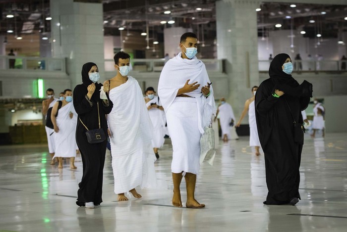 CLARIFIES THAT THE UMRAH PILGRIMAGE CAN BE UNDERTAKEN AT ANY TIME OF THE YEAR -- In this photo released by Saudi Ministry of Hajj and Umrah, Muslims practice social distancing while praying around the Kaaba, the cubic building at the Grand Mosque during the first day umrah pilgrimages were allowed to restart, in the Muslim holy city of Mecca, Saudi Arabia, Sunday, Oct. 4, 2020. The umrah pilgrimage, or smaller pilgrimage, can be undertaken at any time of the year. A very small, limited number of people donning the white terrycloth garment symbolic of the Muslim pilgrimage circled Islams holiest site in Mecca on Sunday after Saudi Arabia lifted coronavirus restrictions that had been in place for months. (Saudi Ministry of Hajj and Umrah via AP)