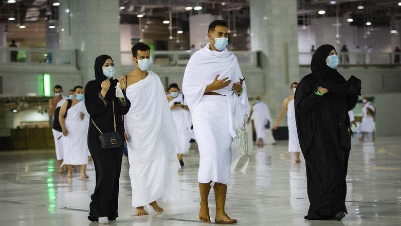 CLARIFIES THAT THE UMRAH PILGRIMAGE CAN BE UNDERTAKEN AT ANY TIME OF THE YEAR -- In this photo released by Saudi Ministry of Hajj and Umrah, Muslims practice social distancing while praying around the Kaaba, the cubic building at the Grand Mosque during the first day umrah pilgrimages were allowed to restart, in the Muslim holy city of Mecca, Saudi Arabia, Sunday, Oct. 4, 2020. The umrah pilgrimage, or smaller pilgrimage, can be undertaken at any time of the year. A very small, limited number of people donning the white terrycloth garment symbolic of the Muslim pilgrimage circled Islams holiest site in Mecca on Sunday after Saudi Arabia lifted coronavirus restrictions that had been in place for months. (Saudi Ministry of Hajj and Umrah via AP)