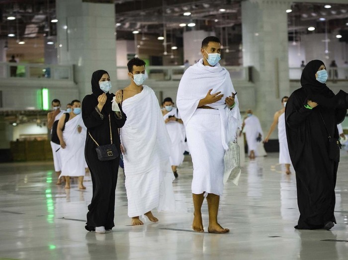 CLARIFIES THAT THE UMRAH PILGRIMAGE CAN BE UNDERTAKEN AT ANY TIME OF THE YEAR -- In this photo released by Saudi Ministry of Hajj and Umrah, Muslims practice social distancing while praying around the Kaaba, the cubic building at the Grand Mosque during the first day umrah pilgrimages were allowed to restart, in the Muslim holy city of Mecca, Saudi Arabia, Sunday, Oct. 4, 2020. The umrah pilgrimage, or smaller pilgrimage, can be undertaken at any time of the year. A very small, limited number of people donning the white terrycloth garment symbolic of the Muslim pilgrimage circled Islams holiest site in Mecca on Sunday after Saudi Arabia lifted coronavirus restrictions that had been in place for months. (Saudi Ministry of Hajj and Umrah via AP)