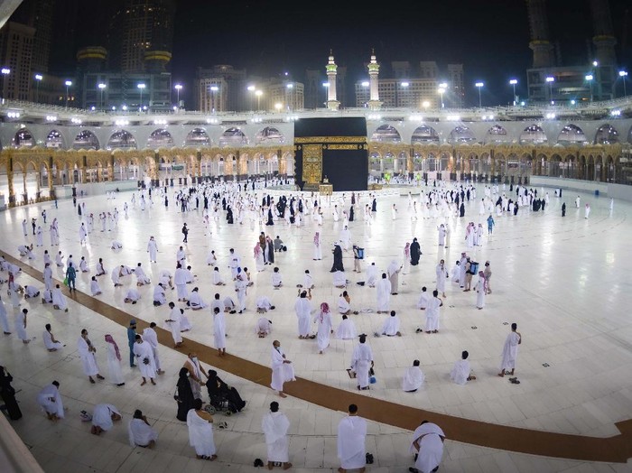 CLARIFIES THAT THE UMRAH PILGRIMAGE CAN BE UNDERTAKEN AT ANY TIME OF THE YEAR -- In this photo released by Saudi Ministry of Hajj and Umrah, Muslims practice social distancing while praying around the Kaaba, the cubic building at the Grand Mosque during the first day umrah pilgrimages were allowed to restart, in the Muslim holy city of Mecca, Saudi Arabia, Sunday, Oct. 4, 2020. The umrah pilgrimage, or smaller pilgrimage, can be undertaken at any time of the year. A very small, limited number of people donning the white terrycloth garment symbolic of the Muslim pilgrimage circled Islams holiest site in Mecca on Sunday after Saudi Arabia lifted coronavirus restrictions that had been in place for months. (Saudi Ministry of Hajj and Umrah via AP)
