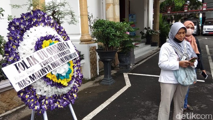 Demo tolak UU Omnibus Law Cipta Kerja terjadi di banyak kota di Tanah Air. Di halaman Gedung DPRD Kota Blitar, ada perempuan yang berdemo seorang diri.