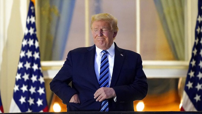 President Donald Trump removes his mask as he stands on the balcony outside of the Blue Room as returns to the White House Monday, Oct. 5, 2020, in Washington, after leaving Walter Reed National Military Medical Center, in Bethesda, Md. Trump announced he tested positive for COVID-19 on Oct. 2. (AP Photo/Alex Brandon)