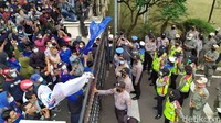 Sempat terjadi gesekan antara petugas keamanan dan massa aksi yang berusaha merangsak masuk ke gedung dewan. 