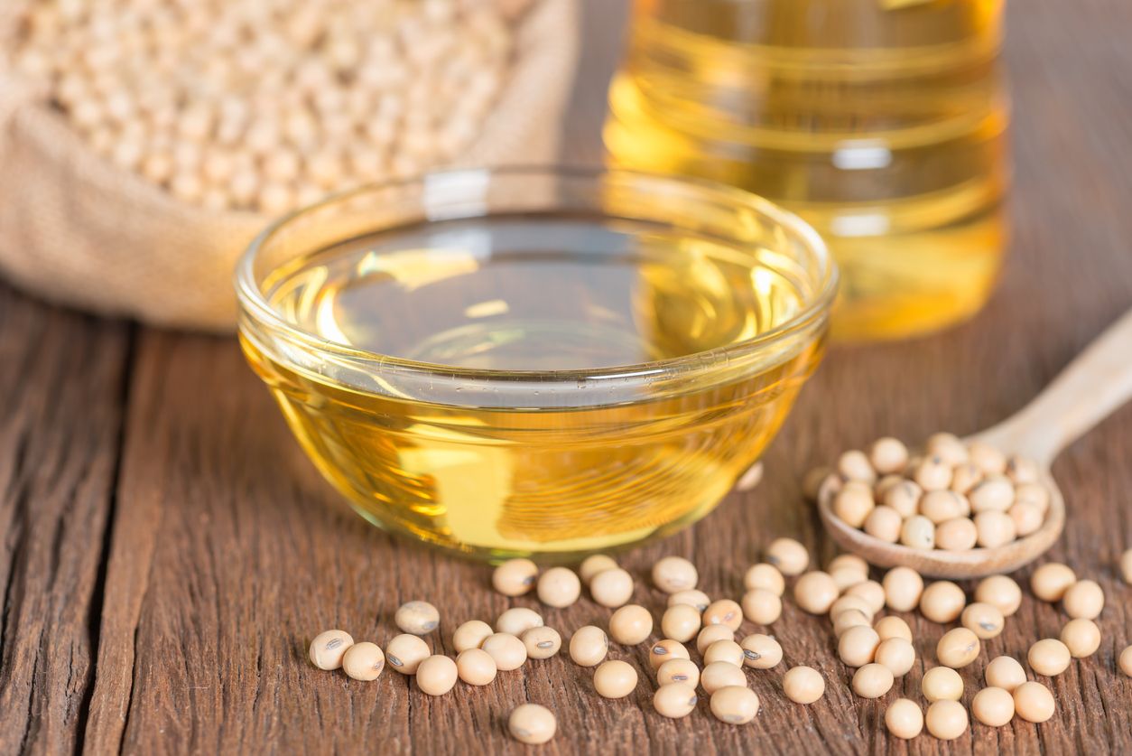 Soybean oil and Soybean on wooden table.