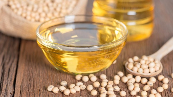 Soybean oil and Soybean on wooden table.